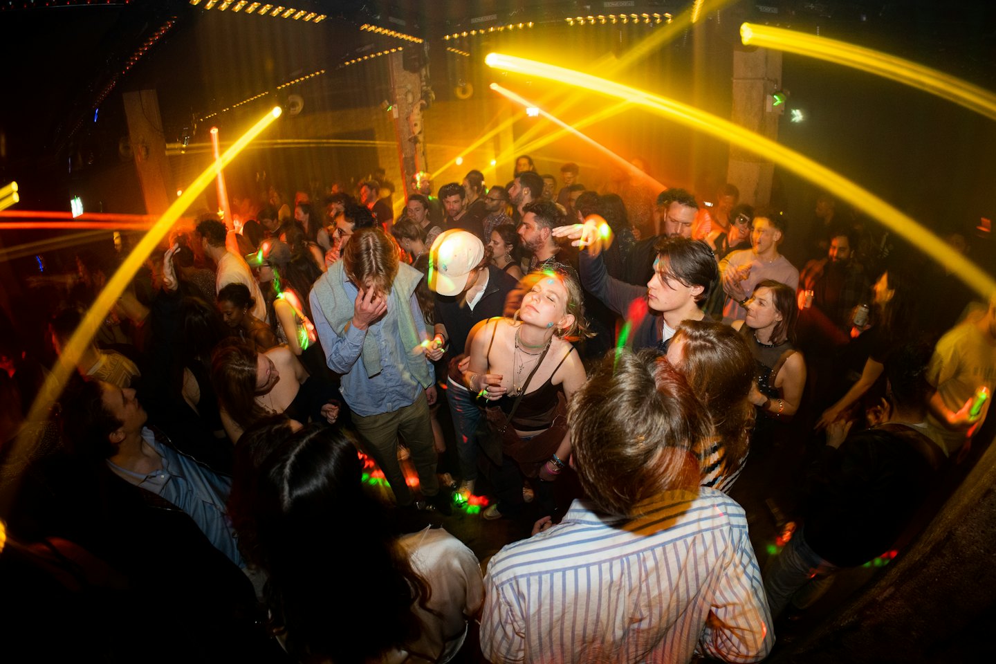 Young adults dancing and socializing in a lively nightclub.